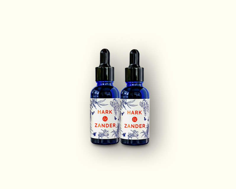 Two blue glass bottles with labels on a white background Hark & Zander